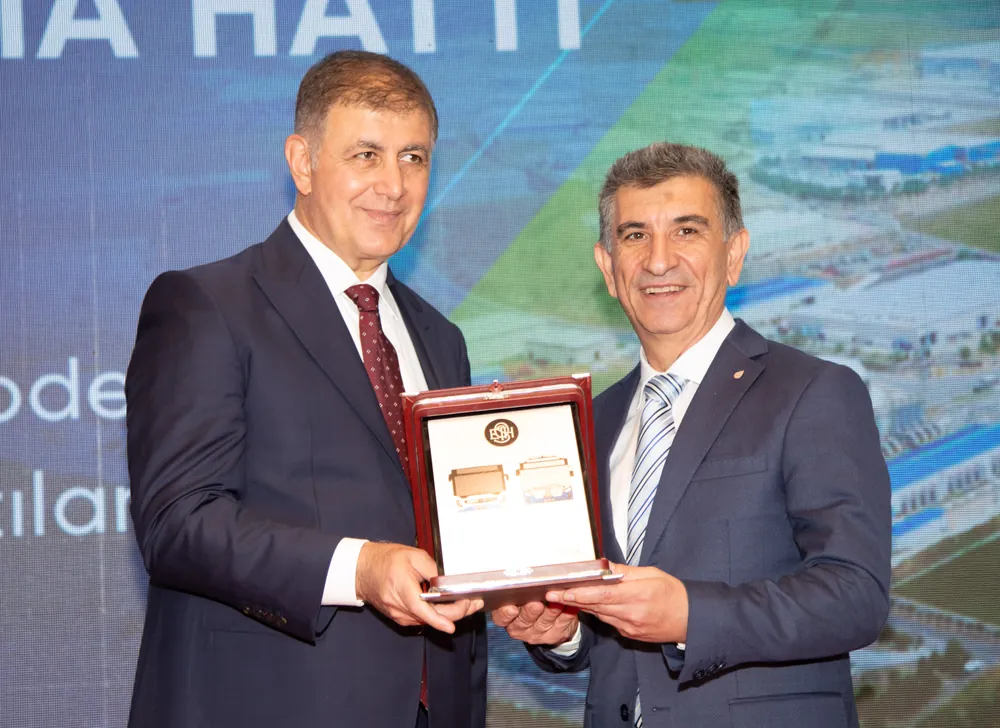 Başkan Cemil Tugay, ALOSBİ'deki projenin diğer bölgelere örnek olmasını dileyerek, Haluk Tezcan'a plaket takdim etti
